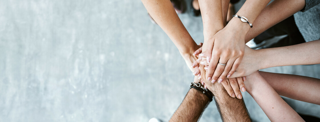 Group of friends stack their hands together, teamwork concept